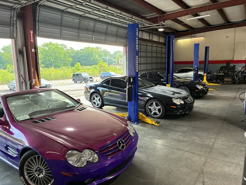 Mercedes-Benz SL-Class cars on lifts inside the DBM Motors shop